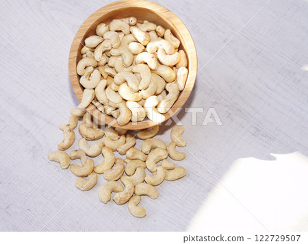 Cashew nuts in wooden bowl on white table with sunshine. Healthy food. 122729507