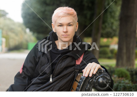 Calm middle-aged woman with short hair and a black jacket outdoors 122730610