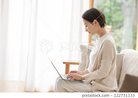 在客廳裡使用電腦的中年女人 122731133