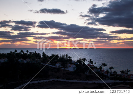Beautiful orange sky in the morning with a brilliant sunrise behind illuminated clouds 122731743