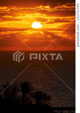the full beautiful round sun rises over the atlantic in the early morning on the Canary Island of Fuerteventura the full beautiful round sun rises over the atlantic in the early morning on the Canary Island of Fuerteventura 122731749