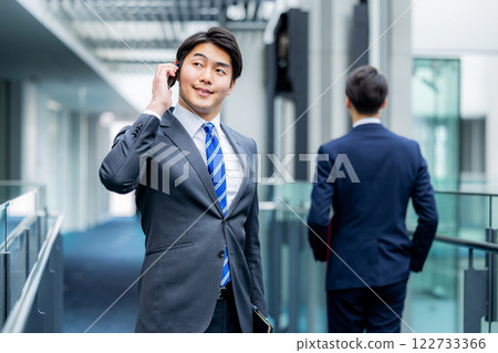 A businessman operating a smartphone at the office A businessman operating a smartphone at the office 122733366