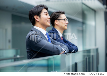 一位男老闆和下屬在辦公室走廊交談 一位男老闆和下屬在辦公室走廊交談 122733367