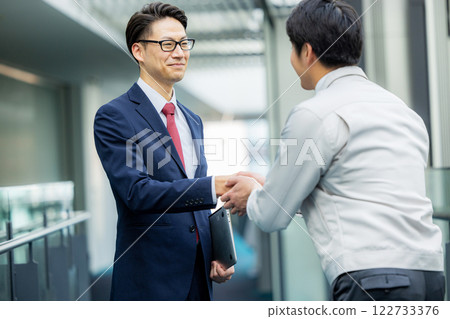 握手：一個穿工作服的男人和一個穿西裝的男人 122733376