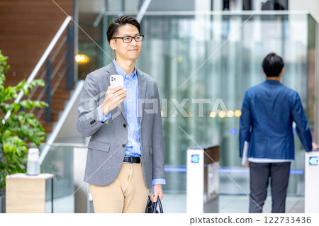 商人拿著智慧型手機在檢票口前 商人拿著智慧型手機在檢票口前 122733436