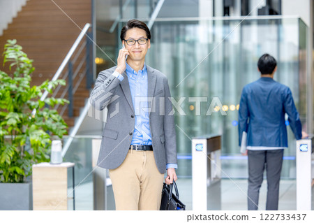 商人拿著智慧型手機在檢票口前 商人拿著智慧型手機在檢票口前 122733437