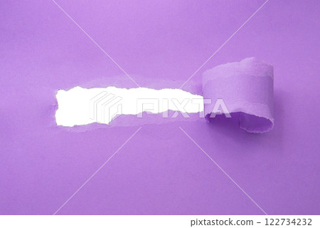 Hole in paper violet color background damaged ripped 122734232