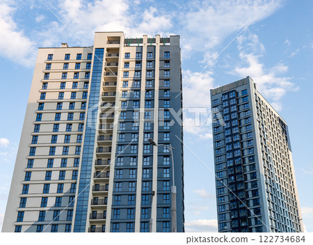Modern high-rise building with sleek facades and large windows in an urban metropolis. Contemporary Modern high-rise building with sleek facades and large windows in an urban metropolis. Contemporary 122734684
