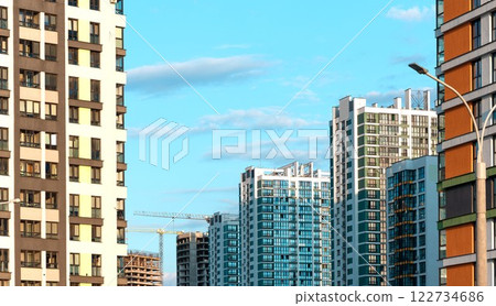 Modern high-rise building in an urban landscape with sleek architecture and large windows. 122734686