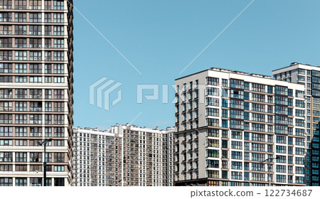 Modern high-rise building in an urban cityscape with glass facades reflecting the sky. Contemporary 122734687