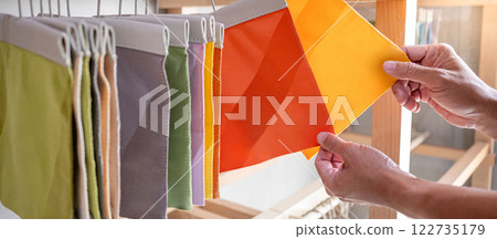 Stylist hand comparing fabric pieces from fabric swatch material Stylist hand comparing fabric pieces from fabric swatch material 122735179
