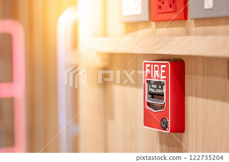 Red fire alarm switch mounted on wooden wall in the office interior Red fire alarm switch mounted on wooden wall in the office interior 122735204