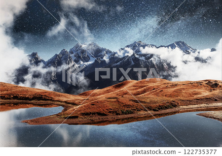 Fantastic starry sky on mountain lake Koruldi. Picturesque night Upper Svaneti, Georgia Europe. Caucasus mountains Fantastic starry sky on mountain lake Koruldi. Picturesque night Upper Svaneti, Georgia Europe. Caucasus mountains 122735377