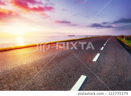 Asphalt road along the sea at sunset 122735379