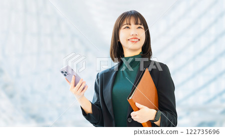 Smiling woman/businesswoman holding a smartphone Smiling woman/businesswoman holding a smartphone 122735696
