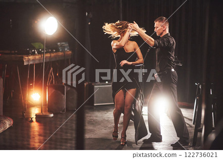 Skillful dancers performing in the dark room under the light 122736021