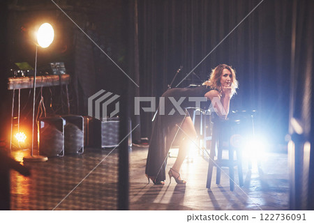 Young sexy woman in black sitting on chair. Retro style film colors effect Young sexy woman in black sitting on chair. Retro style film colors effect 122736091