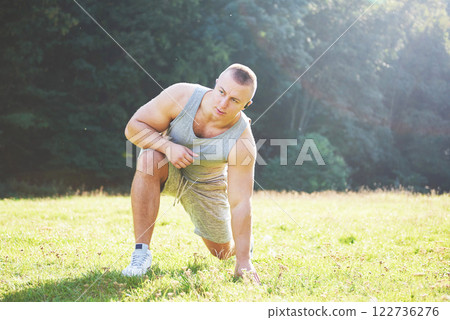 A young sportsman getting ready for athletic and fitness training outdoors. Sport, exercise, fitness, workout. Healthy lifestyle 122736276