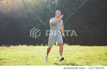 Fitness man athlete jogging in the nature during sunset. Person running working out living an active lifestyle training cardio in summer in sportswear and shoes. Fitness man athlete jogging in the nature during sunset. Person running working out living an active lifestyle training cardio in summer in sportswear and shoes. 122736293