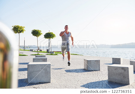 man runner doing stretching exercise, preparing for morning workout in the park man runner doing stretching exercise, preparing for morning workout in the park 122736351