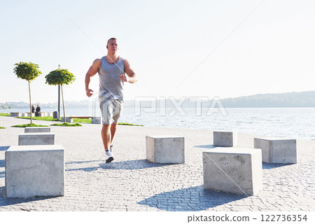 man runner doing stretching exercise, preparing for morning workout in the park man runner doing stretching exercise, preparing for morning workout in the park 122736354
