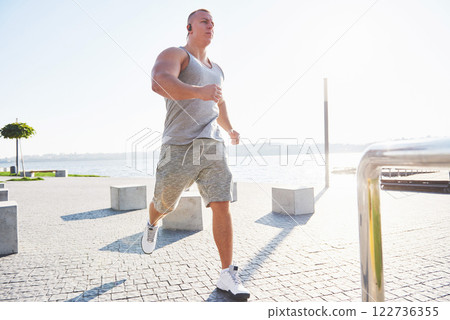 man runner doing stretching exercise, preparing for morning workout in the park man runner doing stretching exercise, preparing for morning workout in the park 122736355