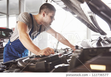 Auto mechanic working in garage. Repair service 122736577
