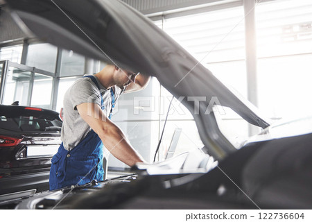 Picture showing muscular car service worker repairing vehicle 122736604