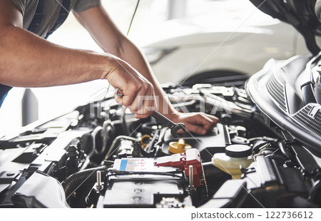 Picture showing muscular car service worker repairing vehicle Picture showing muscular car service worker repairing vehicle 122736612