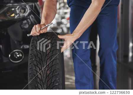 Close up of mechanic showing ok gesture with his thumb while holding a wrench Close up of mechanic showing ok gesture with his thumb while holding a wrench 122736630