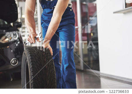 Close up of mechanic showing ok gesture with his thumb while holding a wrench Close up of mechanic showing ok gesture with his thumb while holding a wrench 122736633
