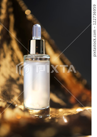 A bottle of cosmetic serum with a pipette on a festive golden background. 122736959
