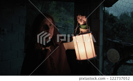 Scared Woman Explores A House In The Countryside At Night With A Lantern In Hand 122737052