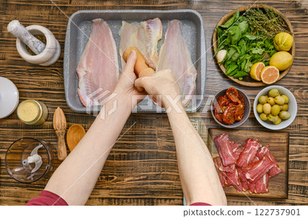 Hands sprinkle fish fillet with salt 122737901