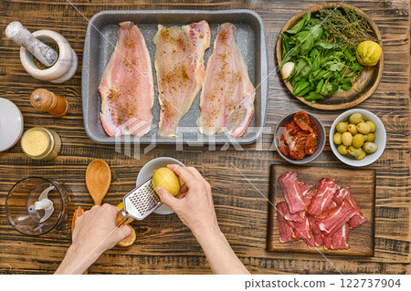 Hands rub the zest of lemon for sauce Hands rub the zest of lemon for sauce 122737904