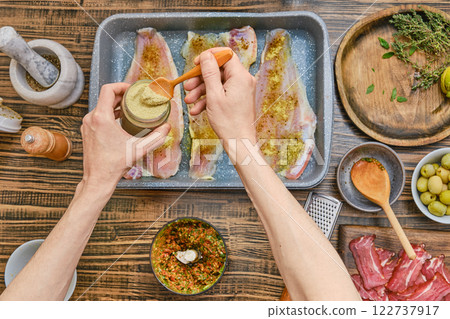 Preparing flavorful seasoning for fresh fish fillets in a cozy kitchen setting 122737917