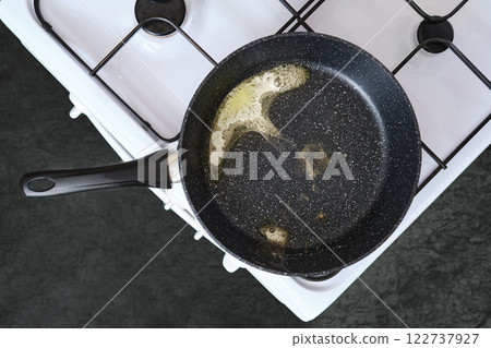 Cooking with butter in a frying pan on a kitchen stove Cooking with butter in a frying pan on a kitchen stove 122737927