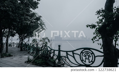 A Misty Waterfront View Complemented by Lush Green Surroundings Evoking Peace and Calmness A Misty Waterfront View Complemented by Lush Green Surroundings Evoking Peace and Calmness 122738621
