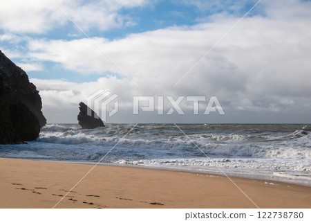 Empty wild sandy beach, Atlantic Ocean seascape, sea waves, beautiful cloudscape, dramatic landscape, travel content, Lisbon, Portugal 122738780