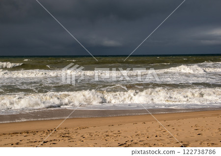 Empty wild sandy beach, Atlantic Ocean seascape, sea waves, beautiful cloudscape, dramatic landscape, travel content, Lisbon, Portugal 122738786