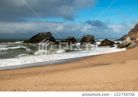 Empty wild sandy beach, Atlantic Ocean seascape, sea waves, beautiful cloudscape, dramatic landscape, travel content, Lisbon, Portugal 122738788
