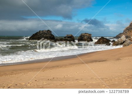 Empty wild sandy beach, Atlantic Ocean seascape, sea waves, beautiful cloudscape, dramatic landscape, travel content, Lisbon, Portugal 122738789