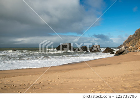 Empty wild sandy beach, Atlantic Ocean seascape, sea waves, beautiful cloudscape, dramatic landscape, travel content, Lisbon, Portugal 122738790