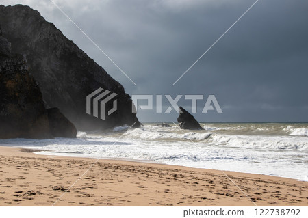Empty wild sandy beach, Atlantic Ocean seascape, sea waves, beautiful cloudscape, dramatic landscape, travel content, Lisbon, Portugal 122738792