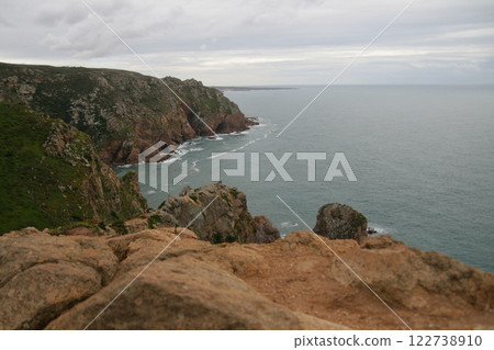 Panorama of the ocean coast and rock bay, Atlantic Ocean in winter, stormy sea waves with white lambs roll ashore with sheer rocks, beautiful cloudscape, dramatic landscape, gloomy seascape 122738910