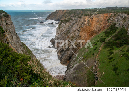 Panorama of the ocean coast and rock bay, Atlantic Ocean in winter, stormy sea waves with white lambs roll ashore with sheer rocks, beautiful cloudscape, dramatic landscape, gloomy seascape Panorama of the ocean coast and rock bay, Atlantic Ocean in winter, stormy sea waves with white lambs roll ashore with sheer rocks, beautiful cloudscape, dramatic landscape, gloomy seascape 122738954