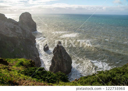 Panorama of the ocean coast and rock bay, Atlantic Ocean in winter, stormy sea waves with white lambs roll ashore with sheer rocks, beautiful cloudscape, dramatic landscape, gloomy seascape Panorama of the ocean coast and rock bay, Atlantic Ocean in winter, stormy sea waves with white lambs roll ashore with sheer rocks, beautiful cloudscape, dramatic landscape, gloomy seascape 122738968