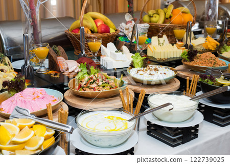Snacks for the holiday, catering. Various snacks. Assortment of salads and buffet dishes. Meat, fish, cheese, salads, fruits and vegetables, sauces and canapes for celebrating a festive event. 122739025