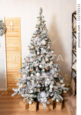 New Year tree with snow on branches with black shelf. decoration in the room with a Christmas tree 122739131
