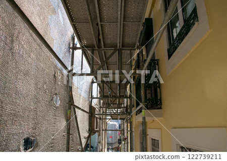 Reconstruction of facade of a historic apartment building on a city street, facade construction mesh covers an old house closed for renovation wall exterior Reconstruction of facade of a historic apartment building on a city street, facade construction mesh covers an old house closed for renovation wall exterior 122739211